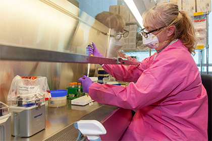 Woman in pink gown working at lab station