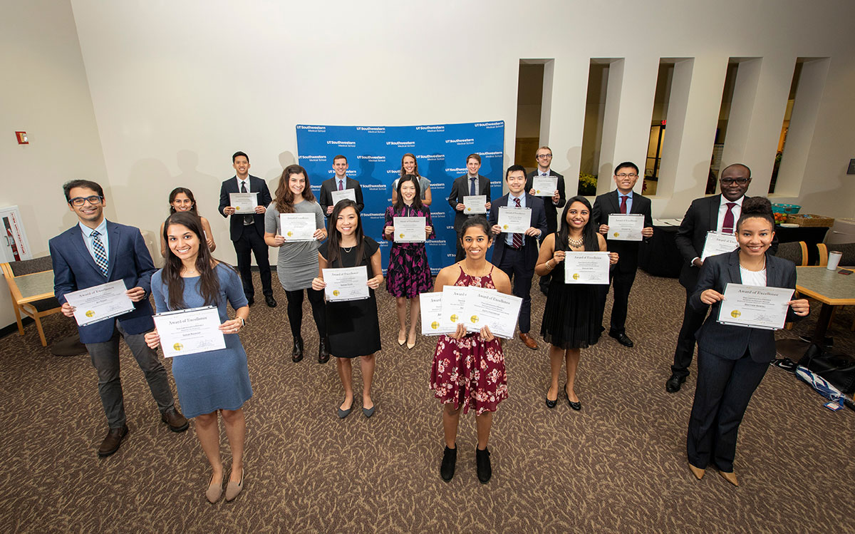 People holding awards while standing distanced from each other