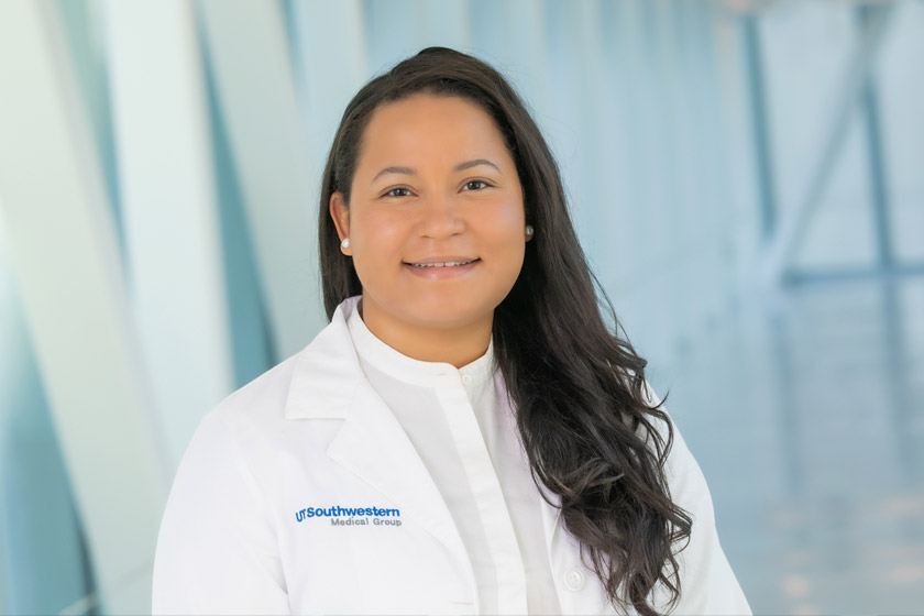 woman with dark hair in white lab coat