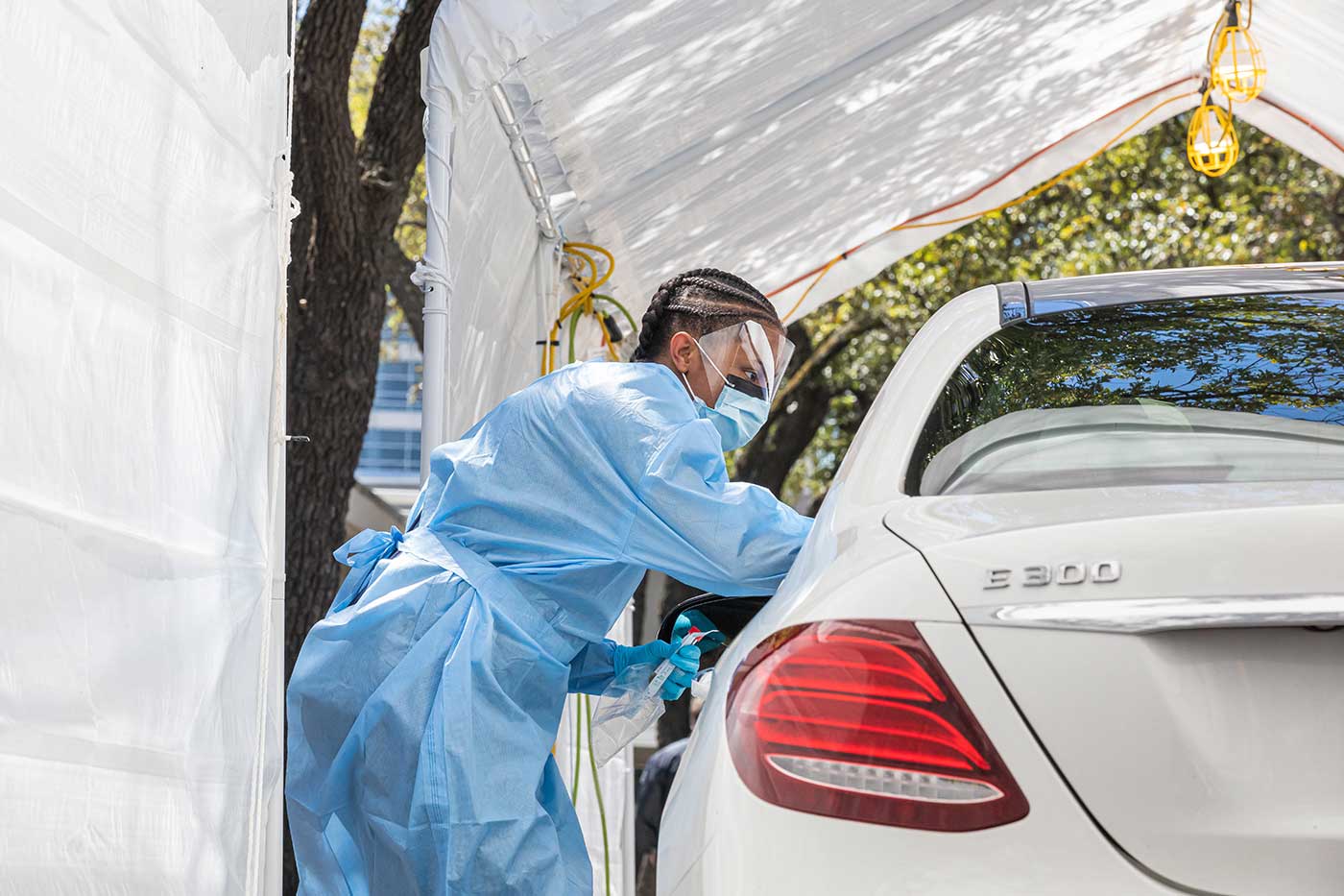 Woman in PPE standing next to an open car window