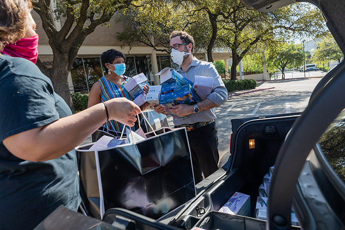 People wearing masks picking up boxes of goods