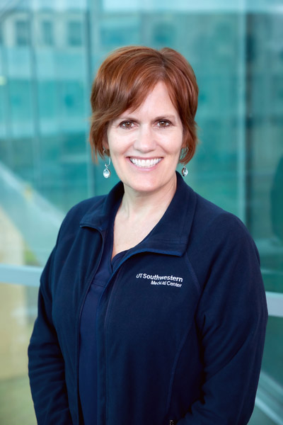 Woman with brown hair, blue collared UTSW shirt