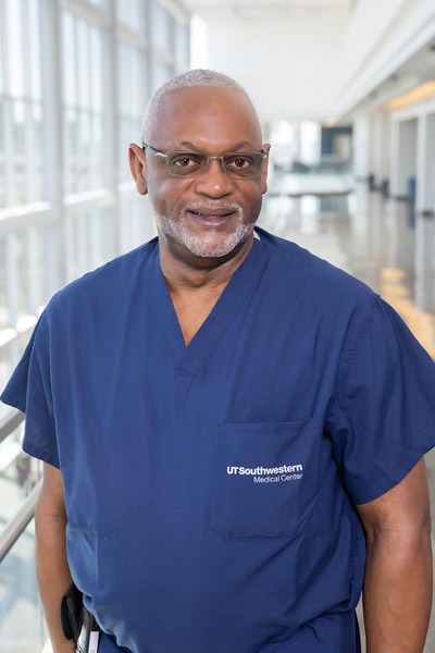 Man with white hair, beard, wore scrubs