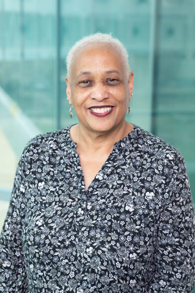 Woman with grey hair, wearing black and white top