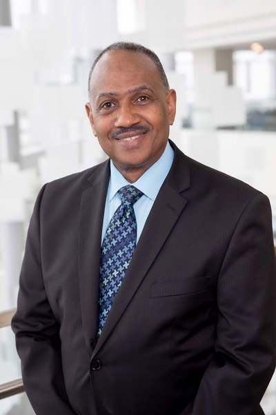 Man with blue tie, wearing black sports jacket and blue tie