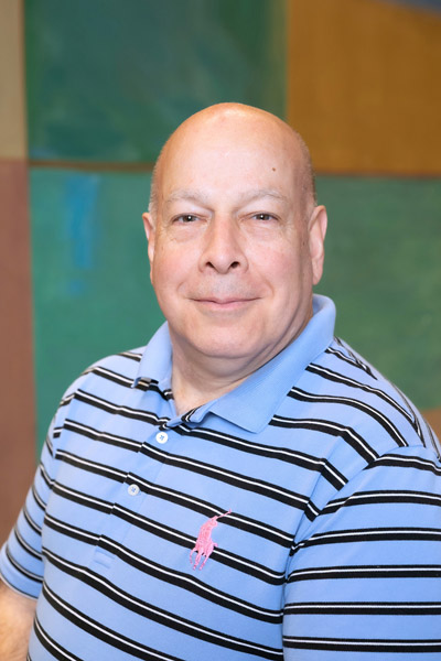 Bald man wearing blue and black striped shirt
