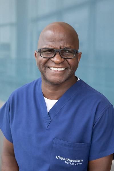 Bald man with glasses, blue scrub top