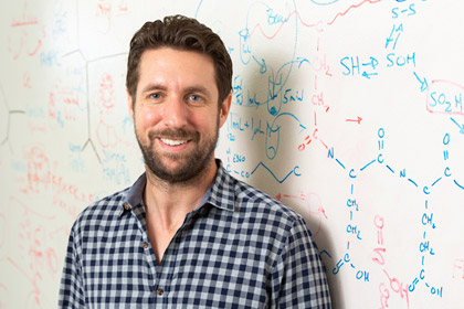 Man standing in front of whiteboard with writing on it