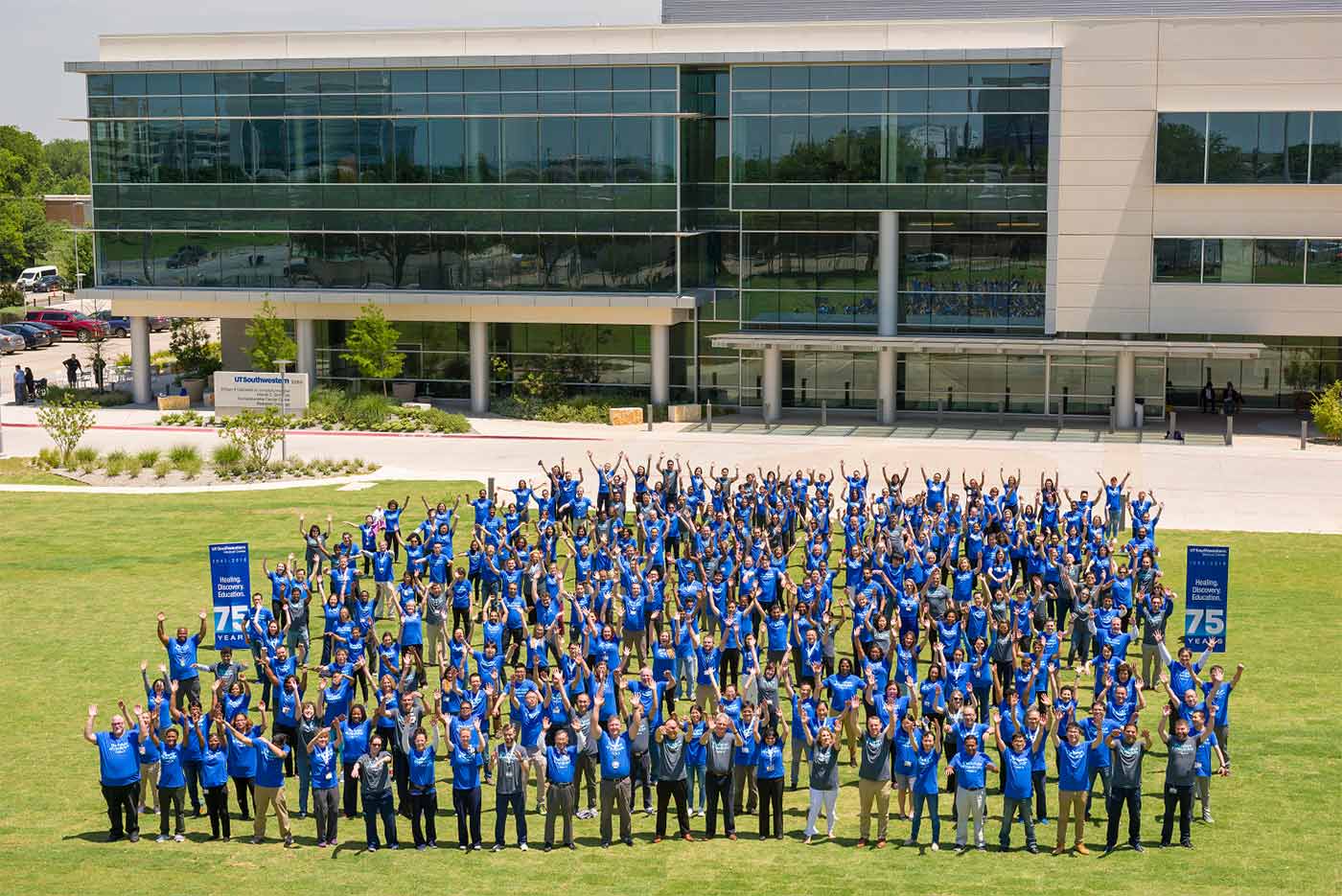 Large group of people outdoors wearing blue shirts