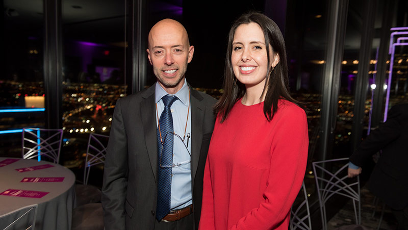 Man in suit and woman in red dress standing side by side