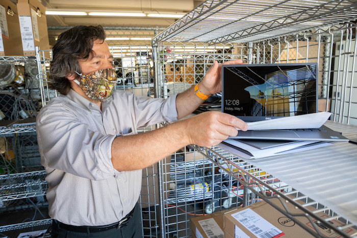 IR employee Vincent Rivera prepares laptops