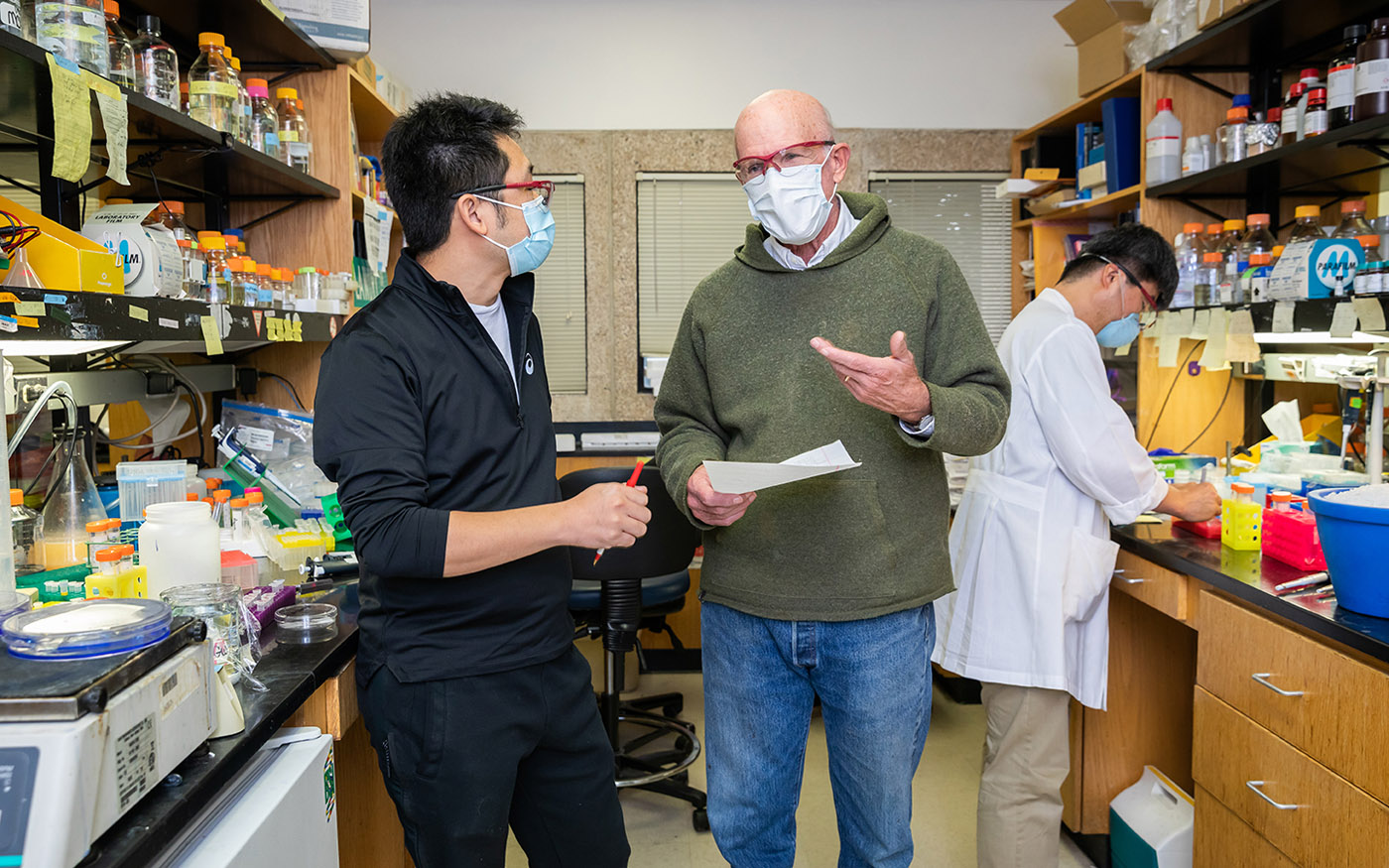 Three men in lab wearing masks