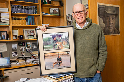 Man holding photos standing in office