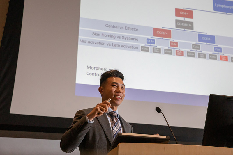 Man in suit standing at podium in front of a screen