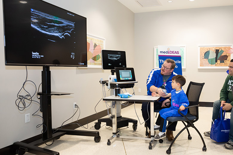 Man demonstrating a sonogram on a boys arm