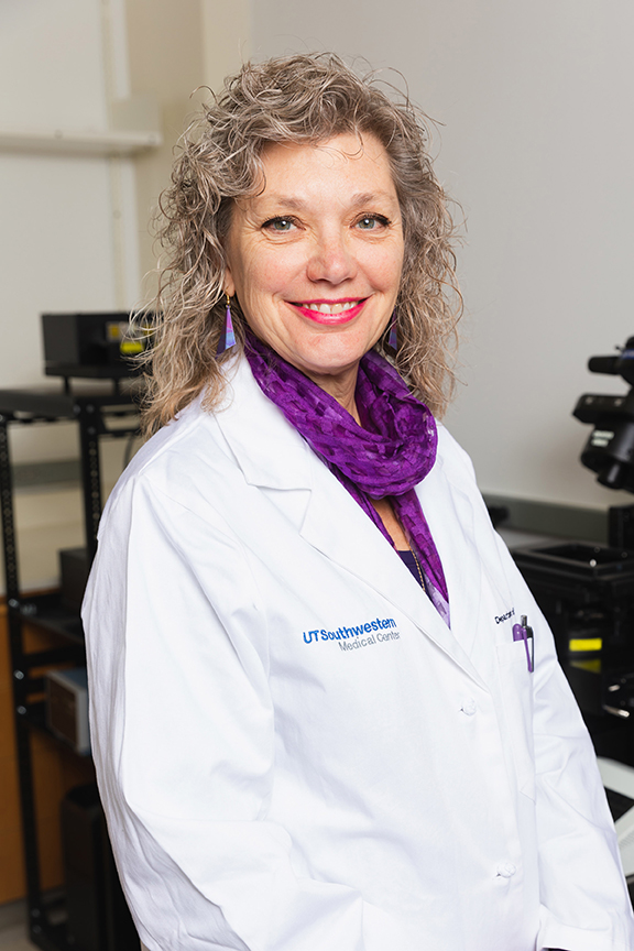 Woman with purple scarf, white lab coat