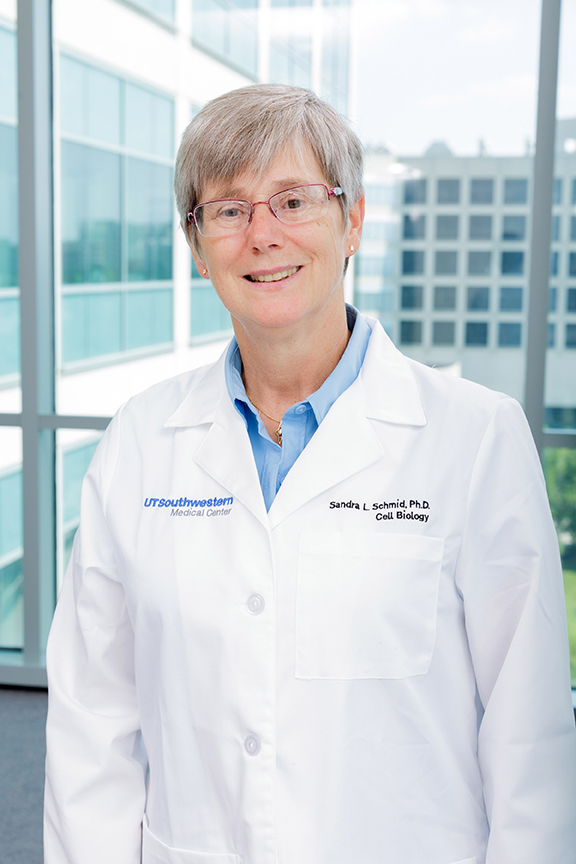 Woman with glasses, blue collared shirt, wearing lab coat