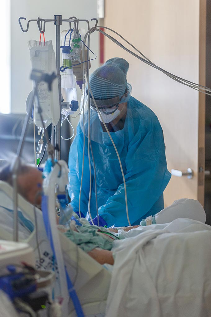 Person in mask and scrubs helps patient