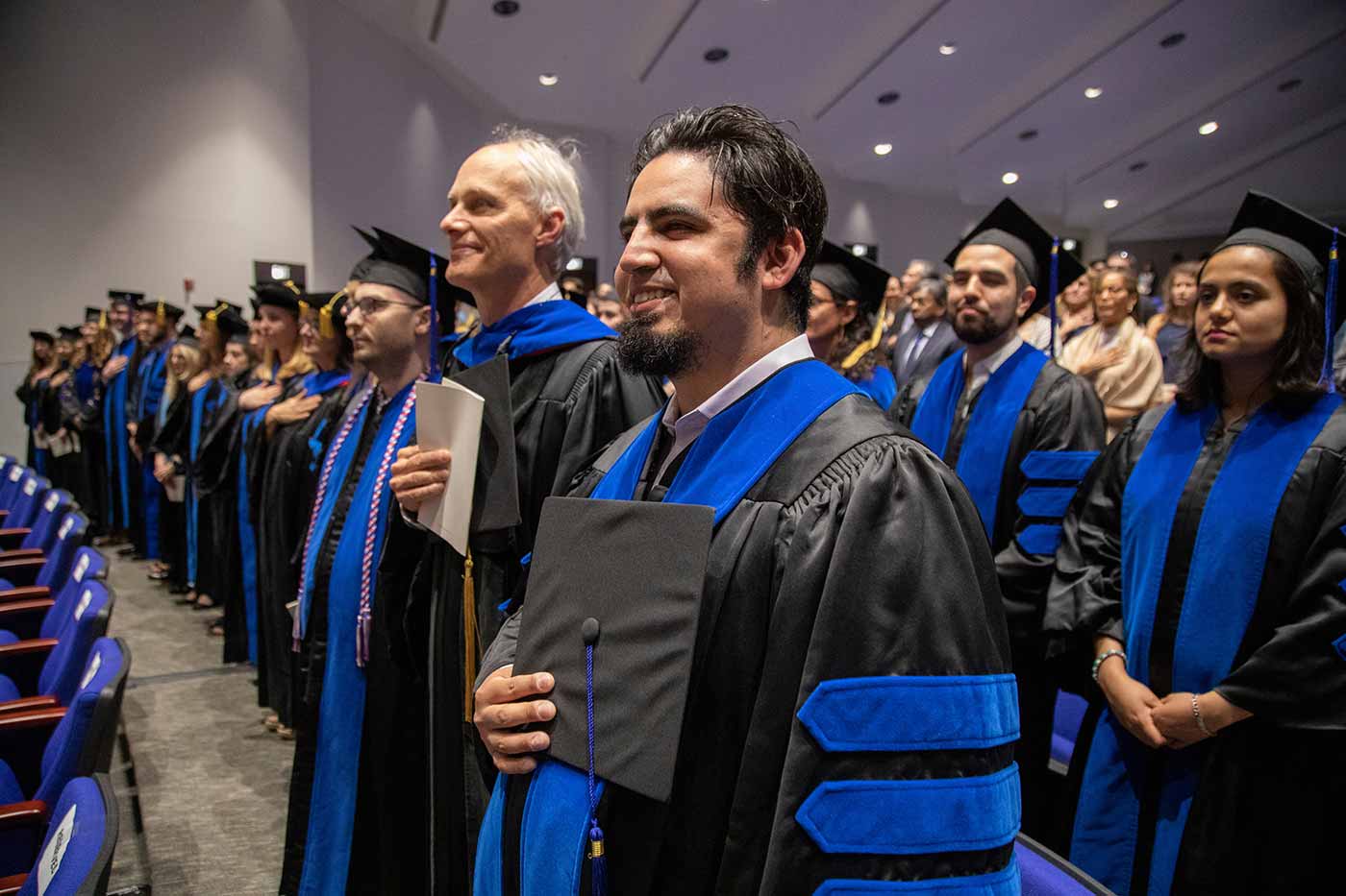 Group of gradutes with caps removed, wearing black gowns