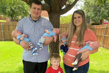 Woman and man holding four babies