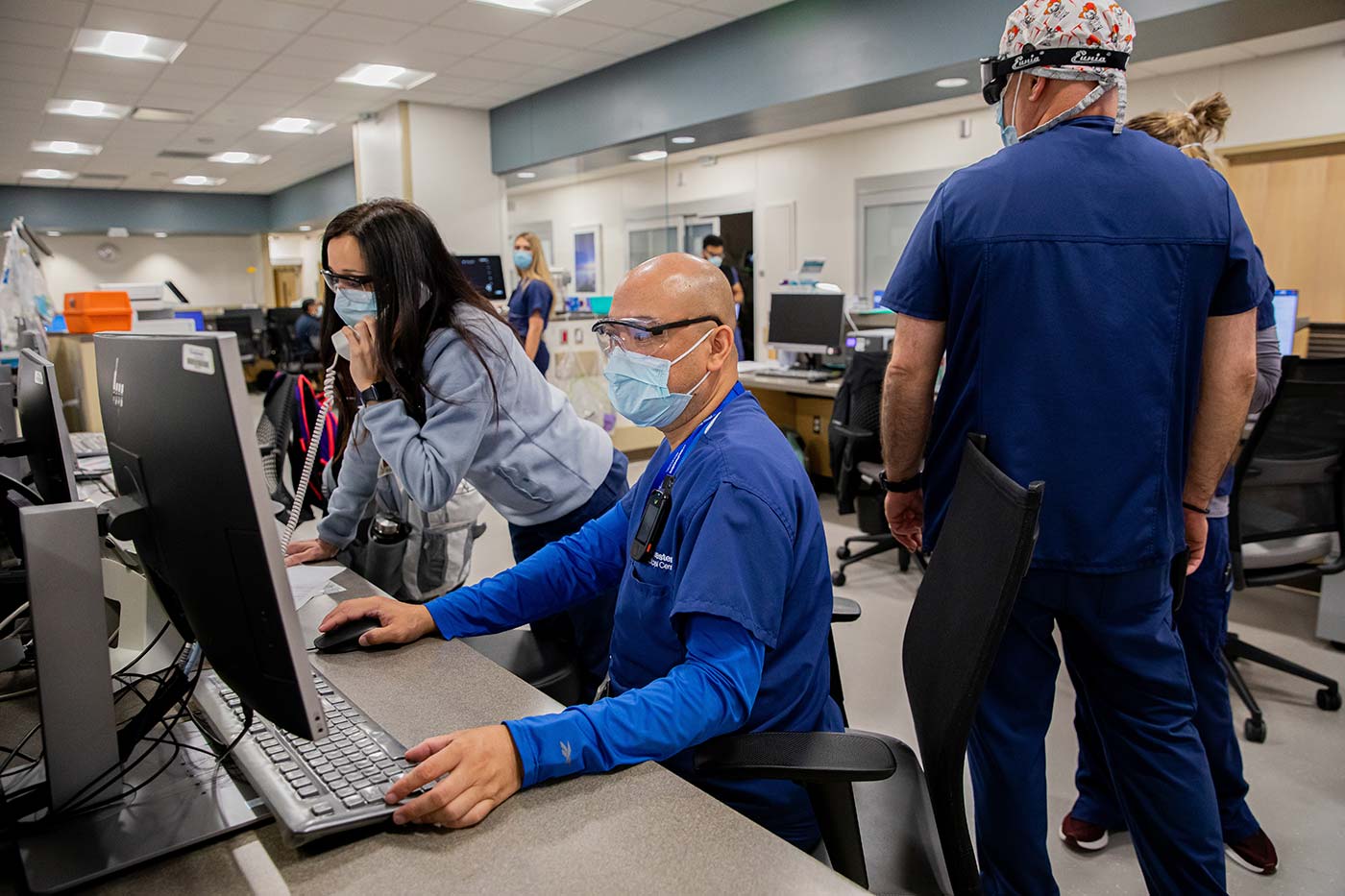 People in scrubs and masks working at computers