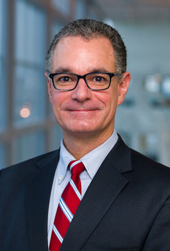 Man with glasses, red tie and blue suit jacket