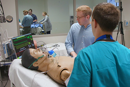 People working over a dummy