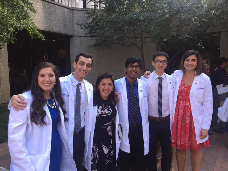 Group of six people in white lab coats