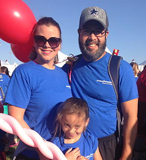 Family of three, all wearing blue shirts