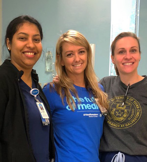 Three women with arms locked, smiling