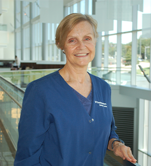 Woman with blonde hair wearing blue scrubs