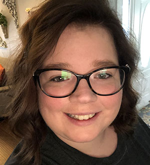 Woman with brown hair, black glasses