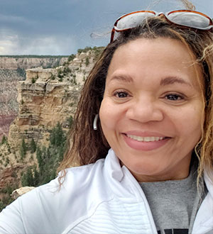 Woman with white jacket, standign by canyon