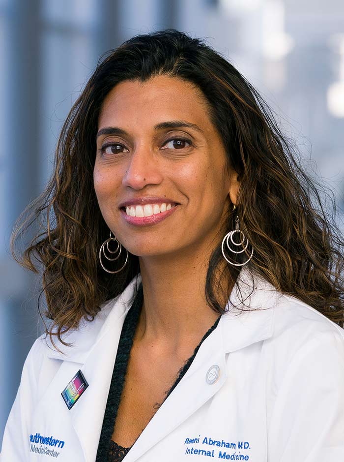 Woman with long dark hair wearing white lab coat