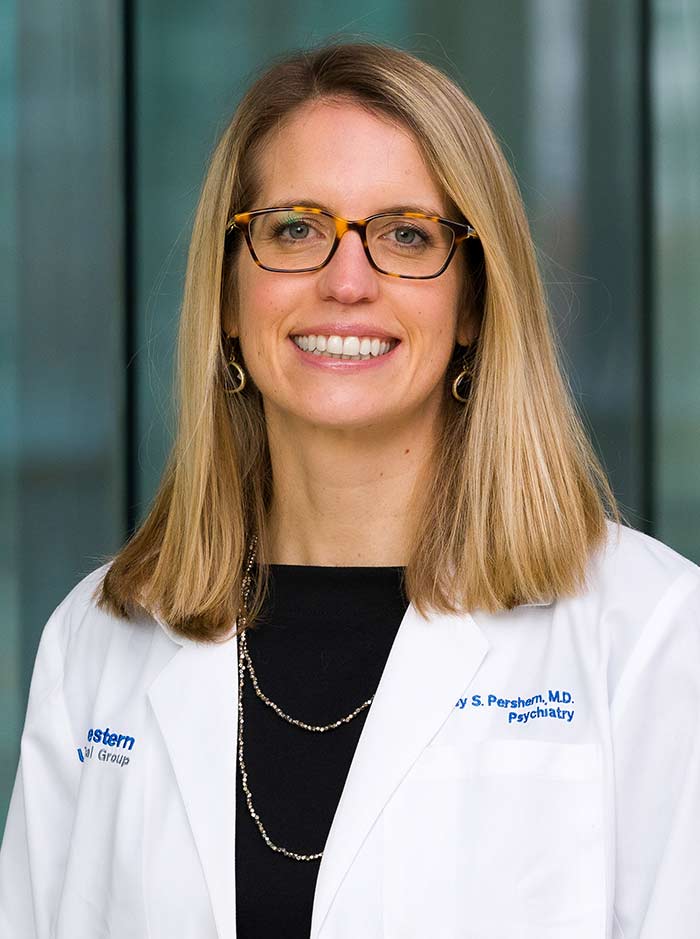 Woman with blond hair, tortoise-shel galsses, wearing white lab coat