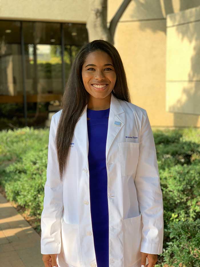 Woman with long hair, wearing white lab coat