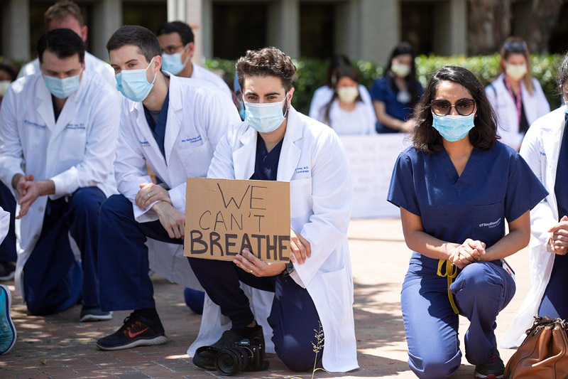 People kneeling and holding signs