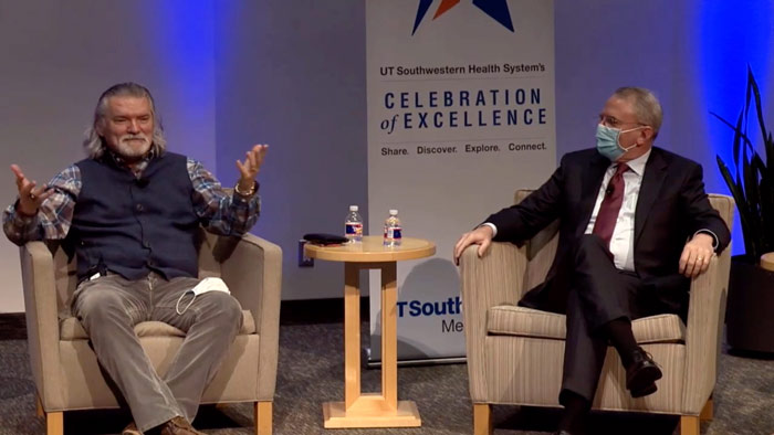 Two men sitting in chairs on stage