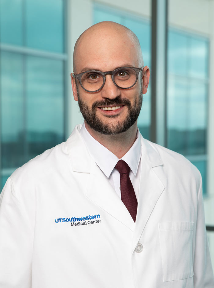 Bald man with beard, glasses, wearing white lab coat