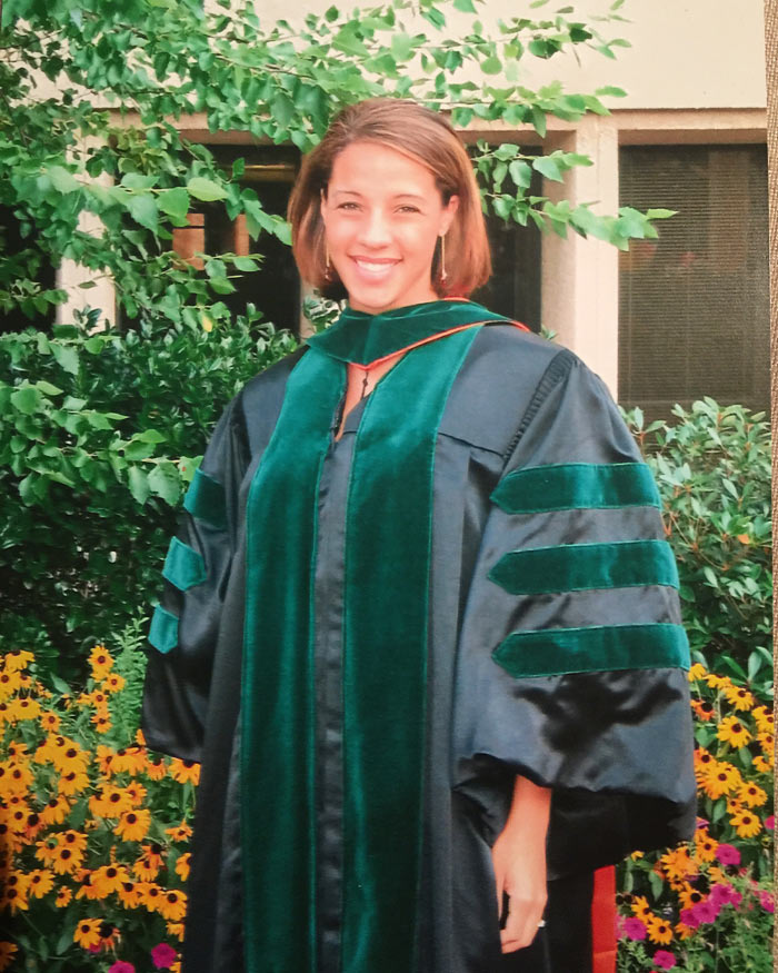 Woman in green graduation gown