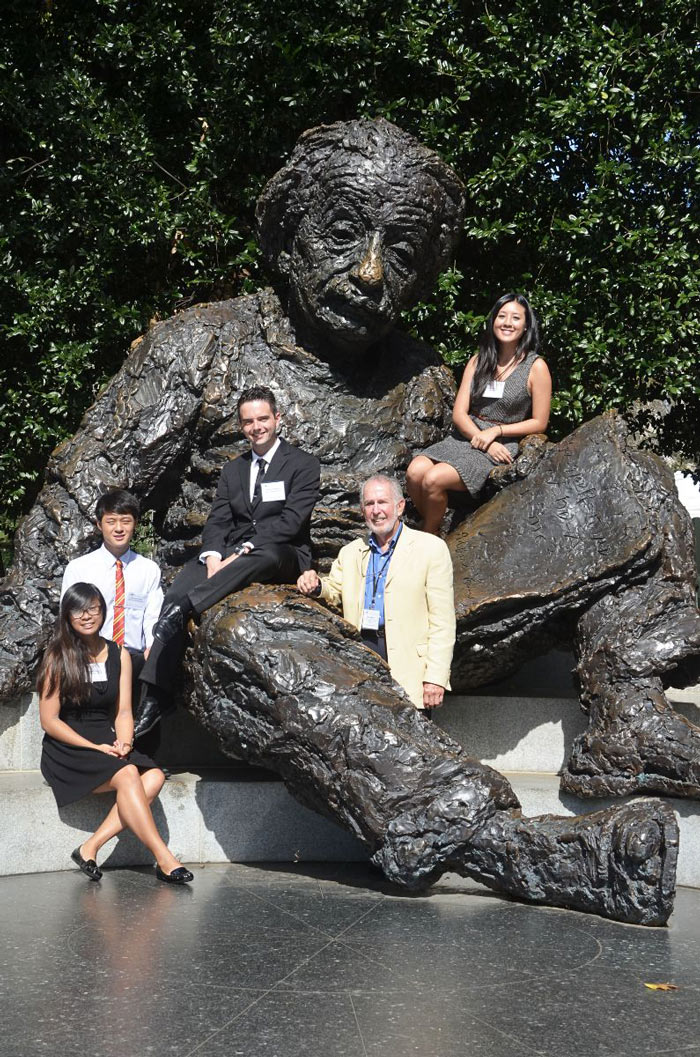 Group of people sitting on statue of Einstein