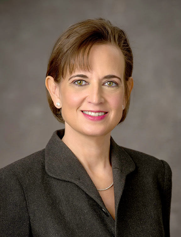 Woman with brown hair in black suit