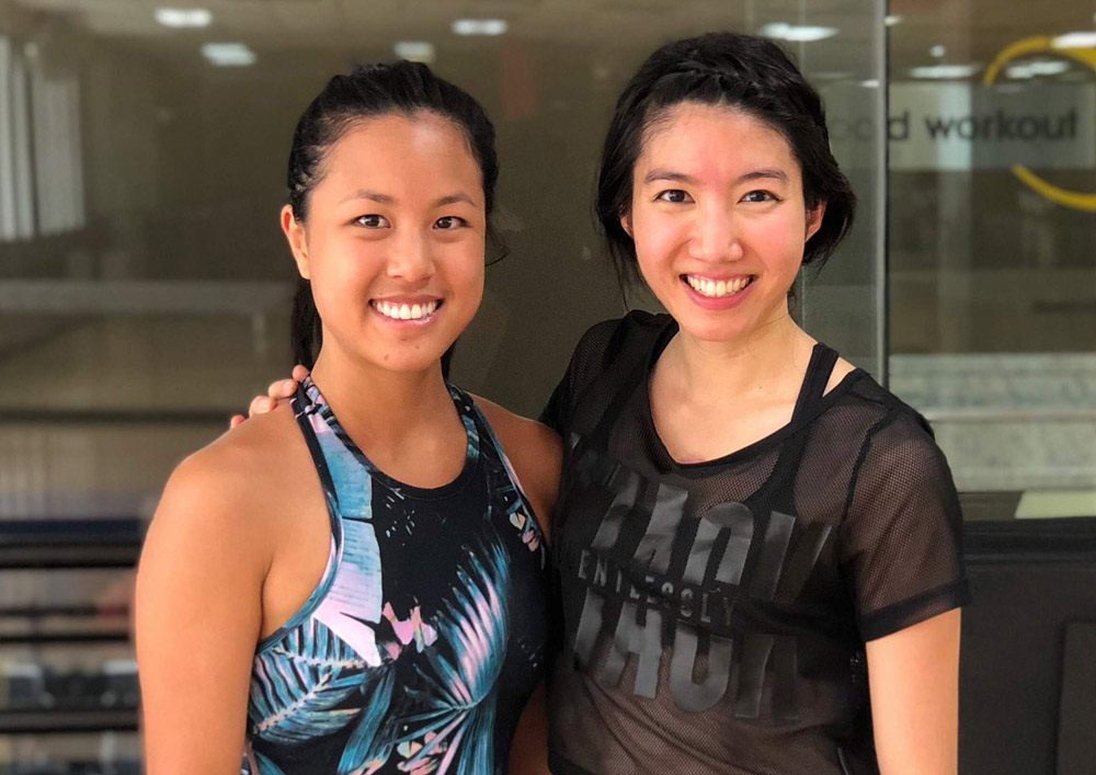 Two women in athletic wear smiling