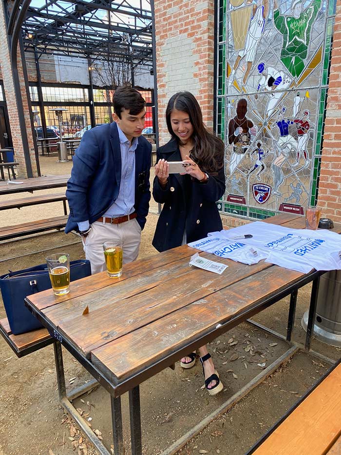 Two people in courtyard reading a note together