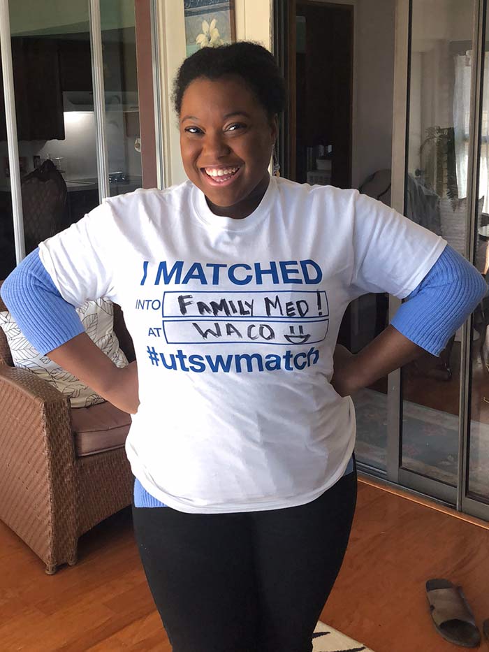 Woman holding shirt that says I matched into family med