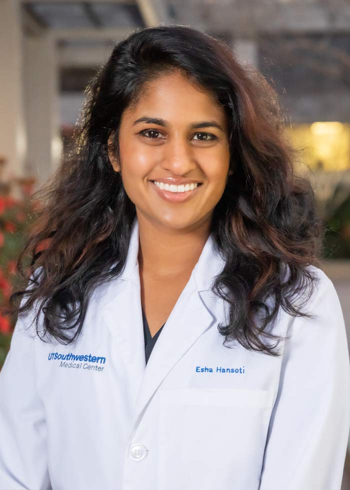 Woman with shoulder-length hair wearing a white labcoat