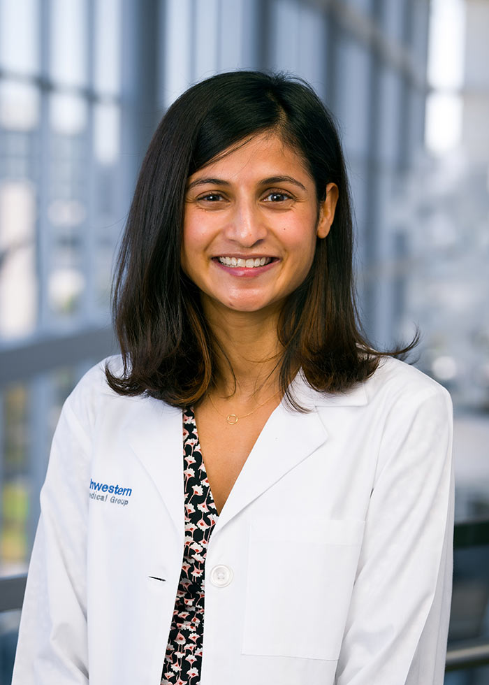 Woman with shoulder-length hair and white lab coat