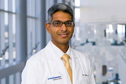 Man in white lab coat and gold tie