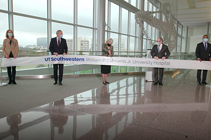 People cutting a large ribbon