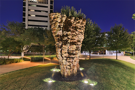 Brown metal sculpture in green area